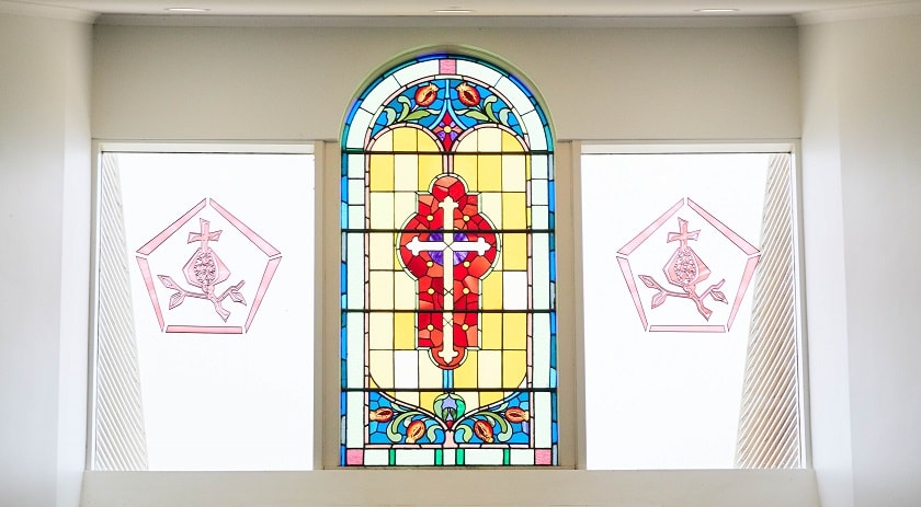 Sunlight illuminating a stained glass window with a cross