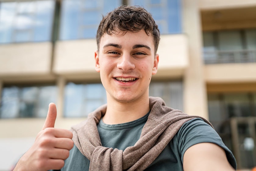 stock image of one man young adult caucasian teenager stand outdoor posing self portrait selfie looking to the camera happy
