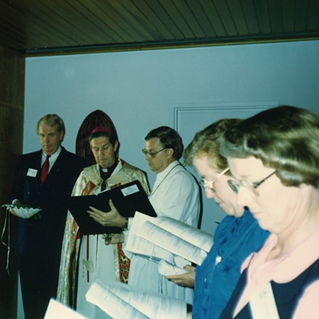 Five individuals reading booklets inside Chapel