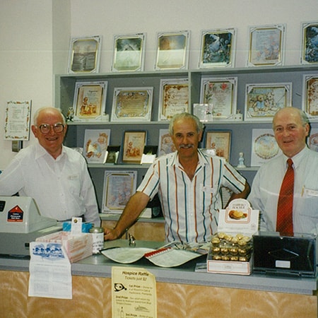 Three Murdoch Auxiliary members standing behind the counter in the Ferns Gift Shop
