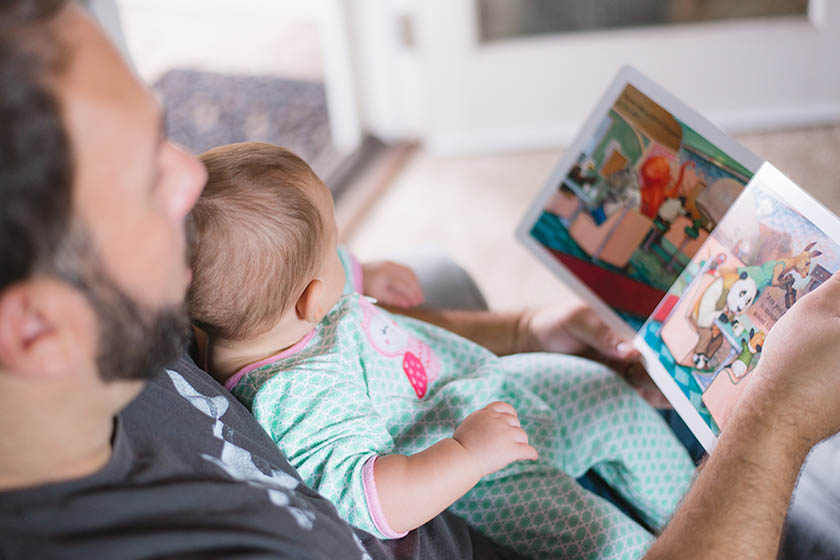 Father with baby on his lap reading a book