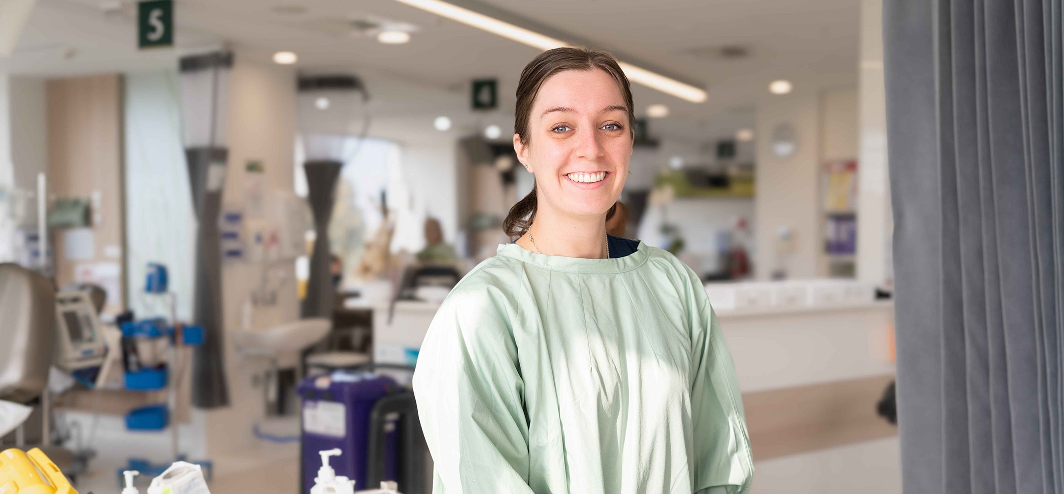 A caregiver in a hospital smiling at the camera.