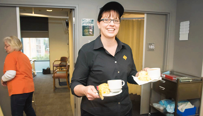 Caregiver bringing afternoon tea to patient