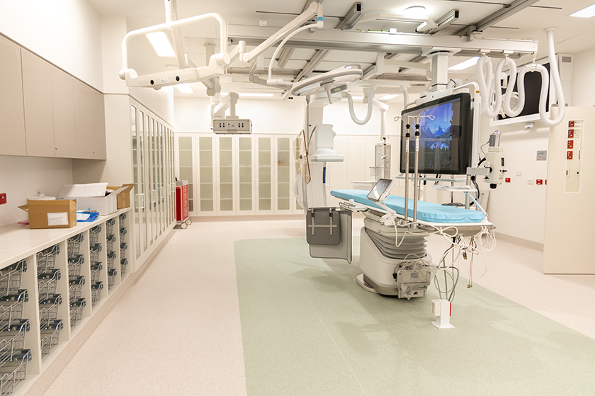 The cath lab showing storage cupboards and operating table.
