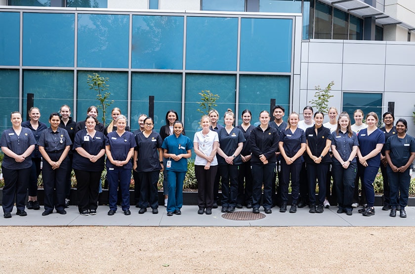 Line-up of 32 graduate nurses smiling for photograph