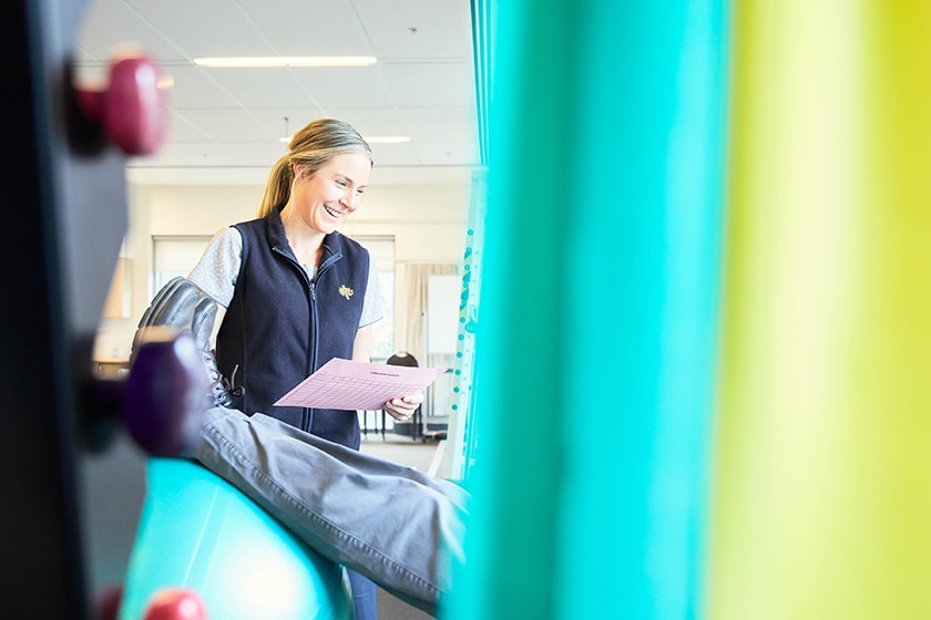 Patient legs on rehabilitation ball with caregiver beside them
