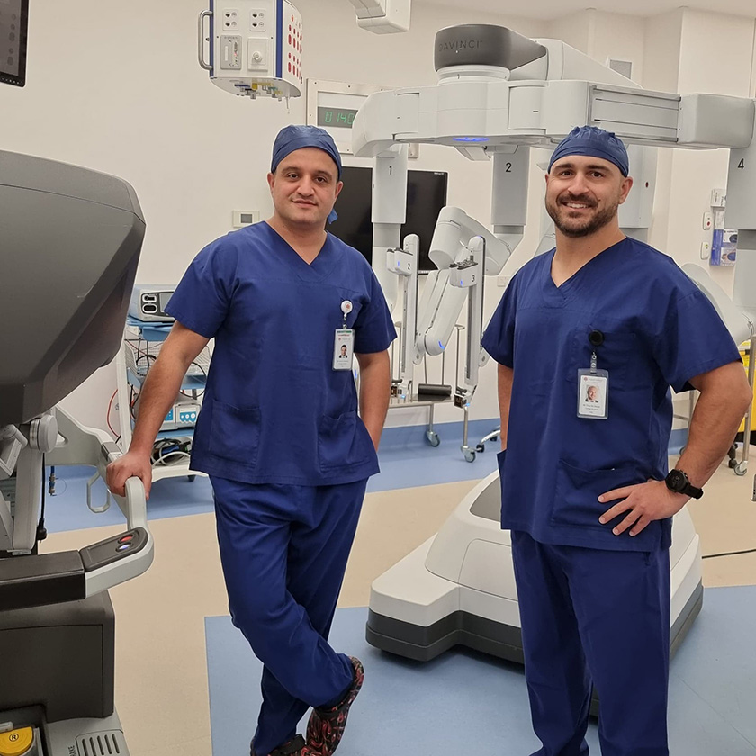 Specialist Urologists Dr Tony de Sousa and Dr Shekib Shabaz standing in a clinical setting wearing scrubs