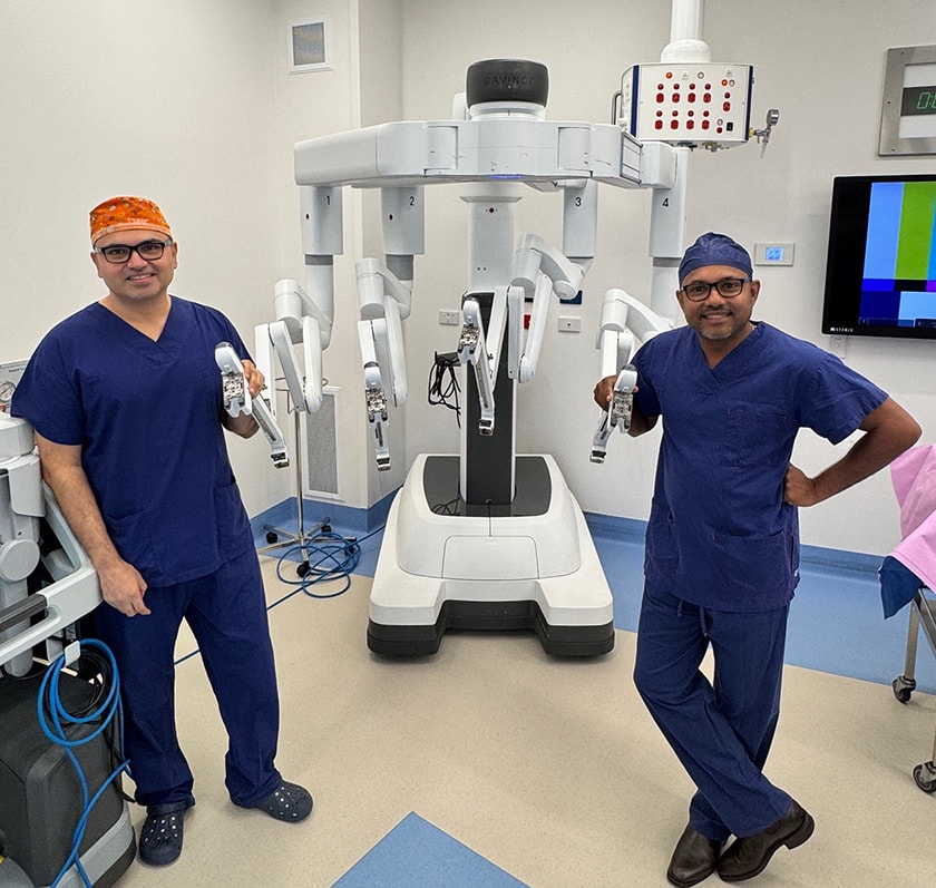 St John of God Berwick Hospital Gynaecologist Dr Saj Rathnayake and Colorectal Surgeon Mr Hanumant Chouhan hold the robotic arm of the da Vinci surgical system