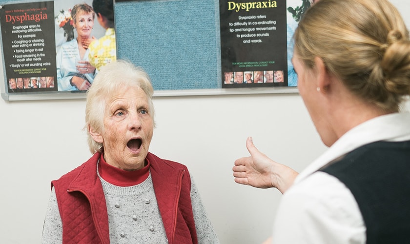 Caregiver with patient conducting speech pathology