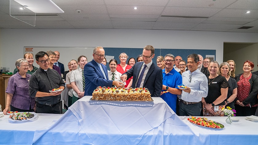 Bishop George Kolodziej and St John of God Bunbury Hospital CEO Jack Harding cut the cake to celebrate the blessing of the Door of Hope with caregivers and community members. Photo: Michelle Tan