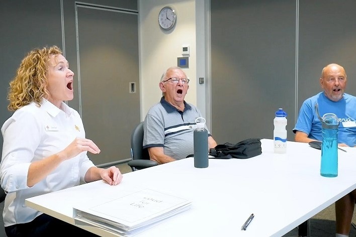 A female caregiver and two male patients participating in the voice technique program.
