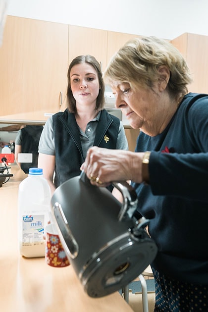 Caregiver and patient making a hot drink using the kettle