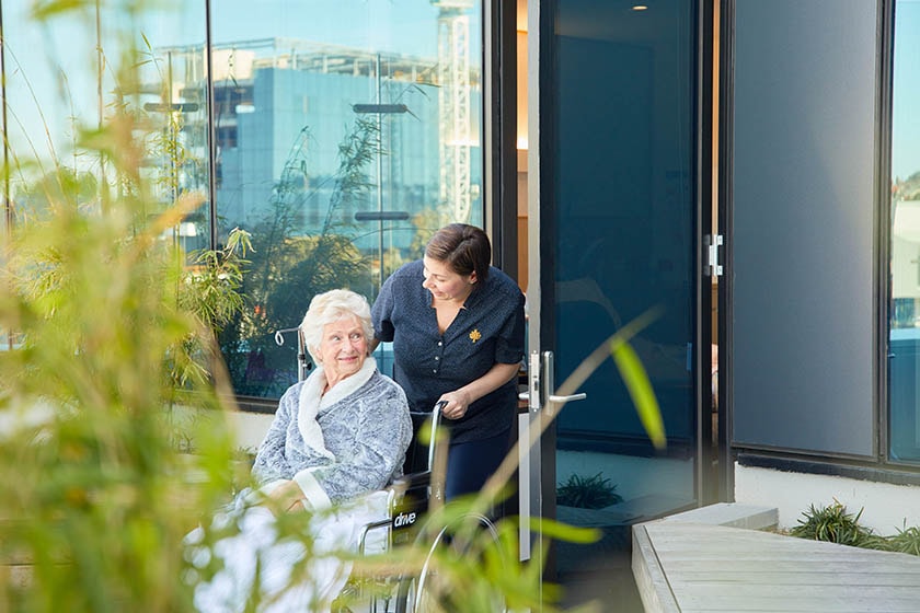 Caregiver and patient in outdoor area.