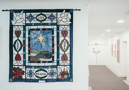 St John of God Geraldton Hospital corridor with textile artwork hanging on wall