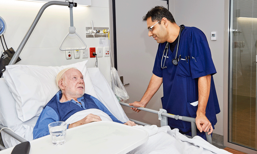 Doctor speaking to patient who is in bed