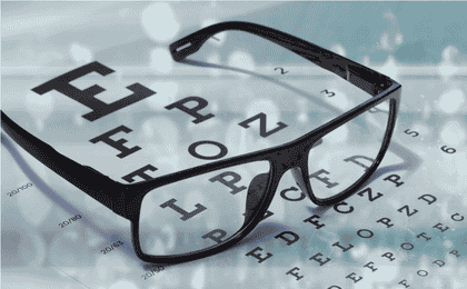Photo of spectacles on top of an eye test chart