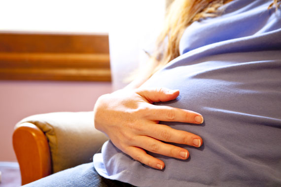 Woman tenderly holding her baby bump