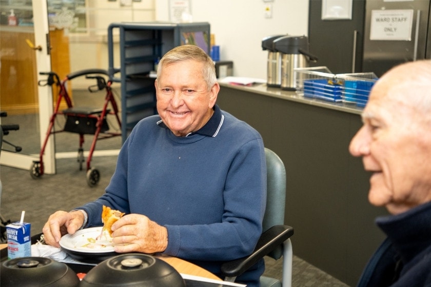 A person sitting down eating food at a table.