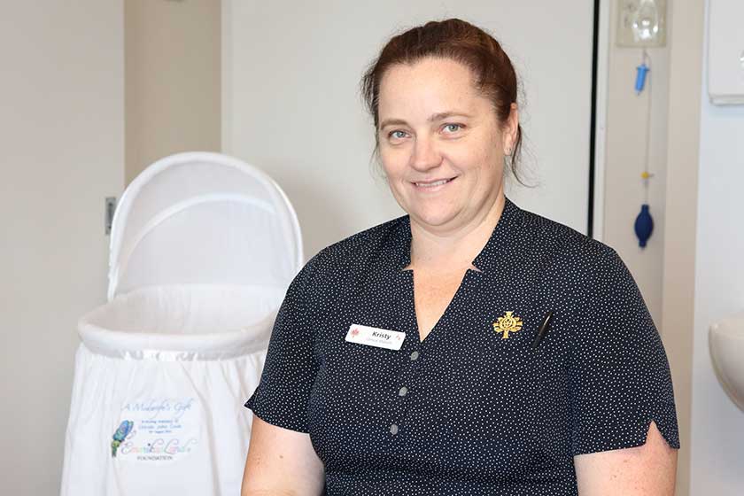 Midwife Kristy Weigele with cuddle cot in background  