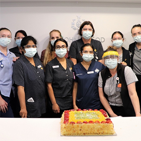 Group of nurses with large cake