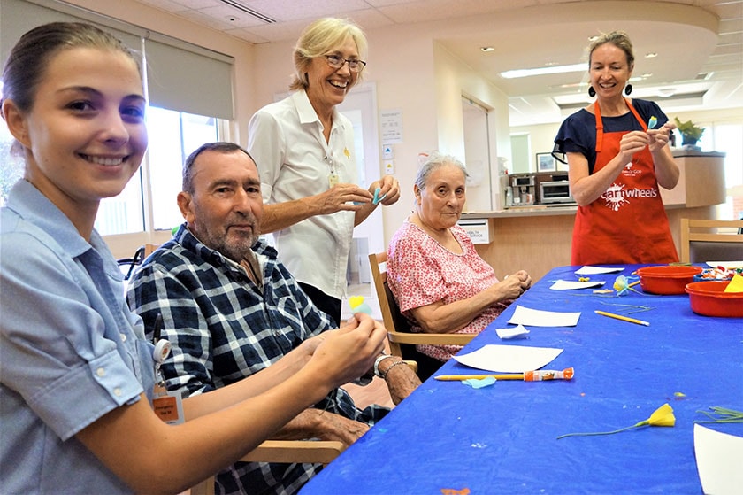 Art program coordinator leading an art workshop with two patients and two caregivers