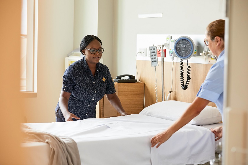 Caregivers making a patient bed