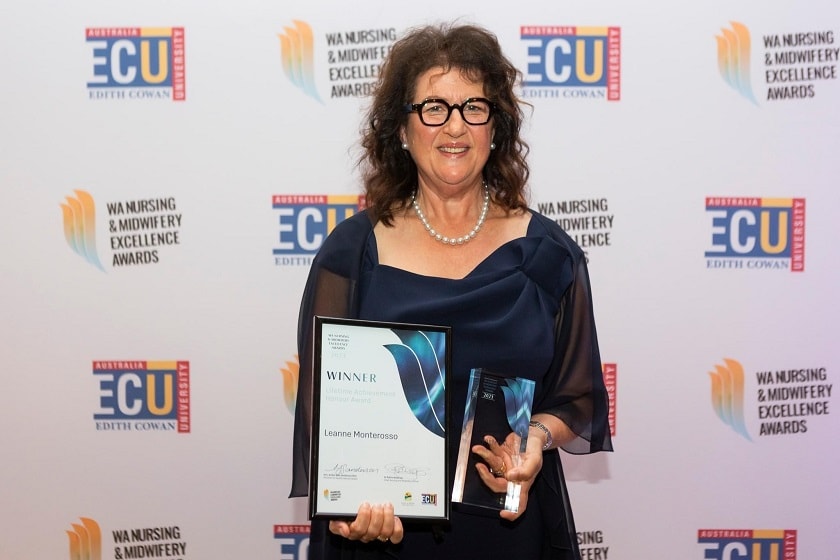 Professor Leanne Monterosso holding her award and smiling at the camera.