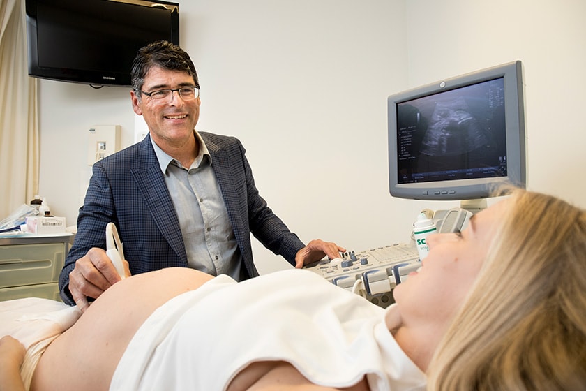 Dr Adam Gubbay using ultrasound on pregnant woman 