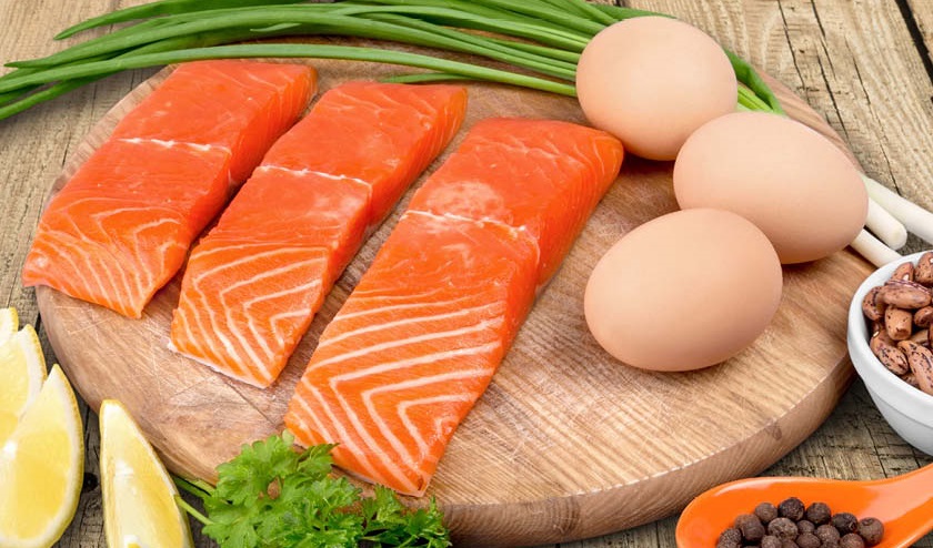 Close up of salmon, eggs, nuts, parsley, lemon and spring onions