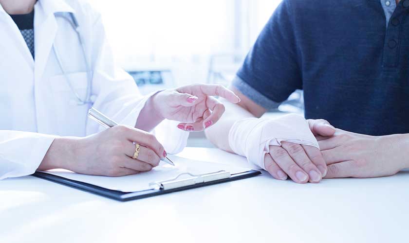 Doctor talking to man who has hurt hand