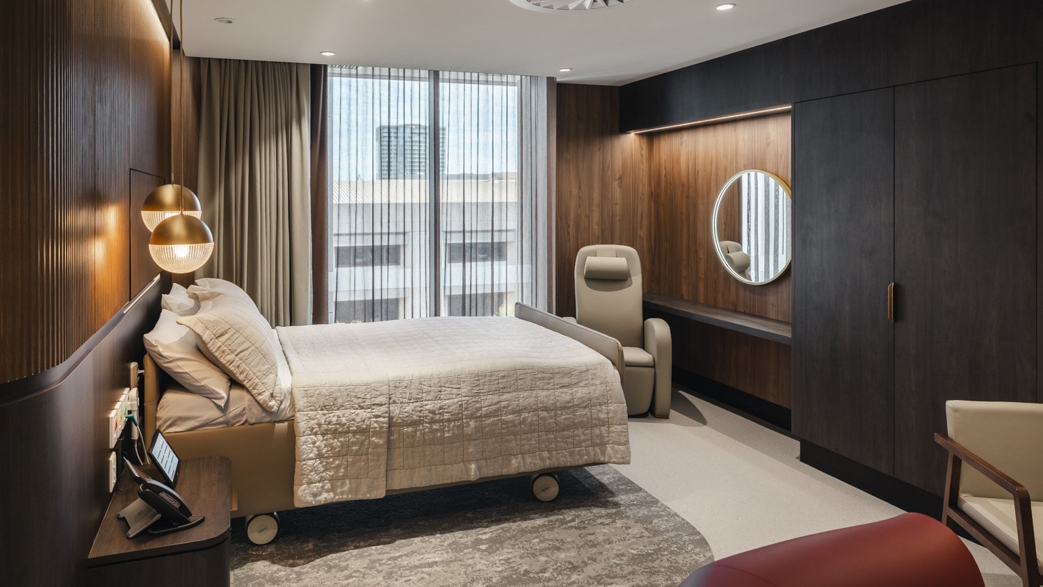 A photo of the interior of one of The Suites showing the bed, lighting and wood panelling decoration.