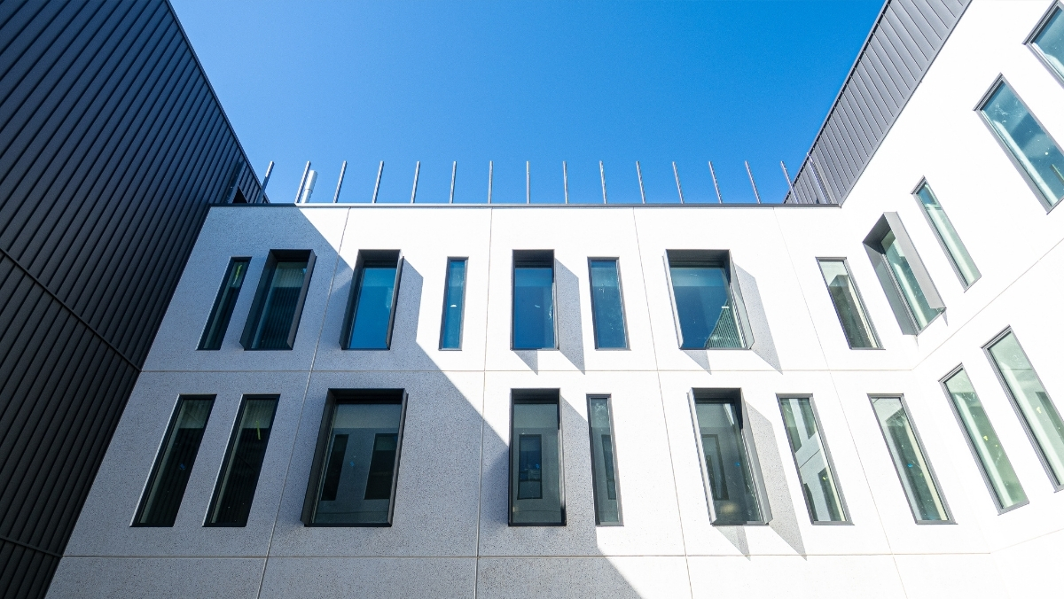 A u-shaped white wall with narrow windows