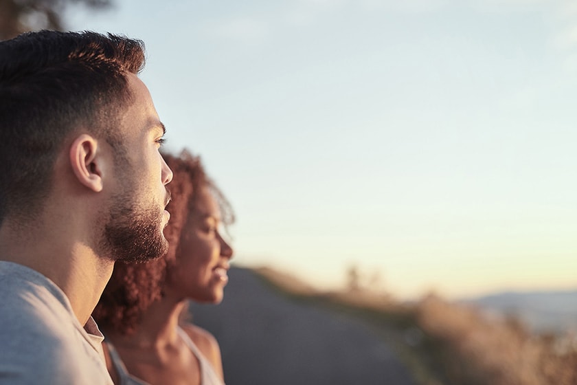 Two people looking at a view across a mountain valley.