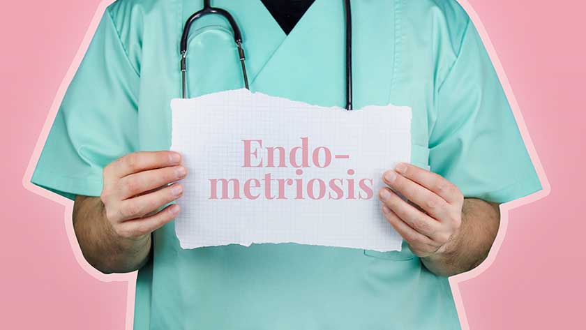 Person in scrubs holding up sign that says 'endometriosis'