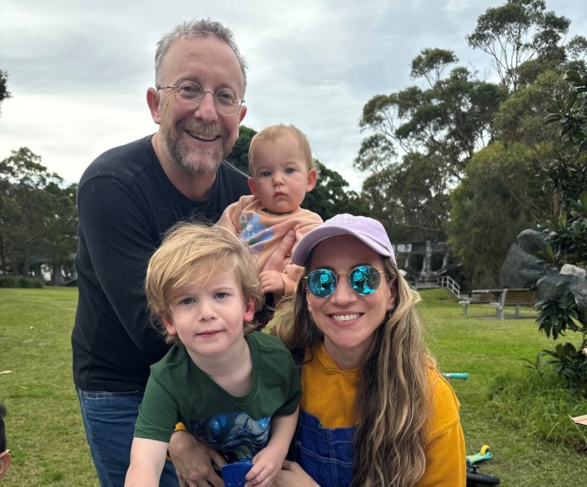 Dylan, his wife and two children smile for a family photo.