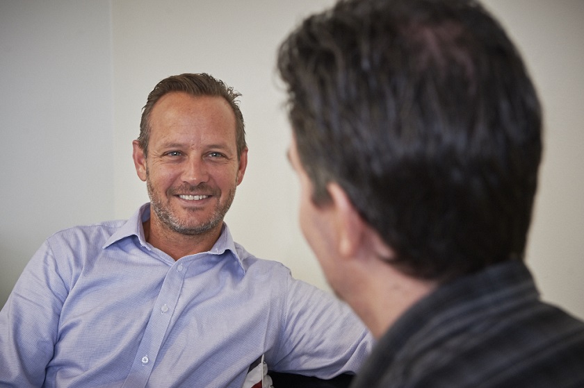 Health care professional sitting facing a patient in a consultation room