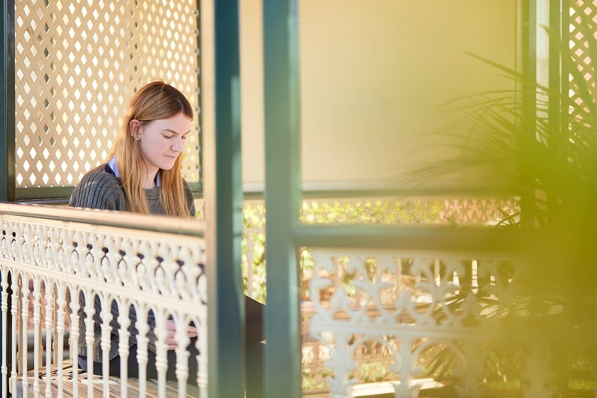 Young adult sitting outdoors in a gazebo