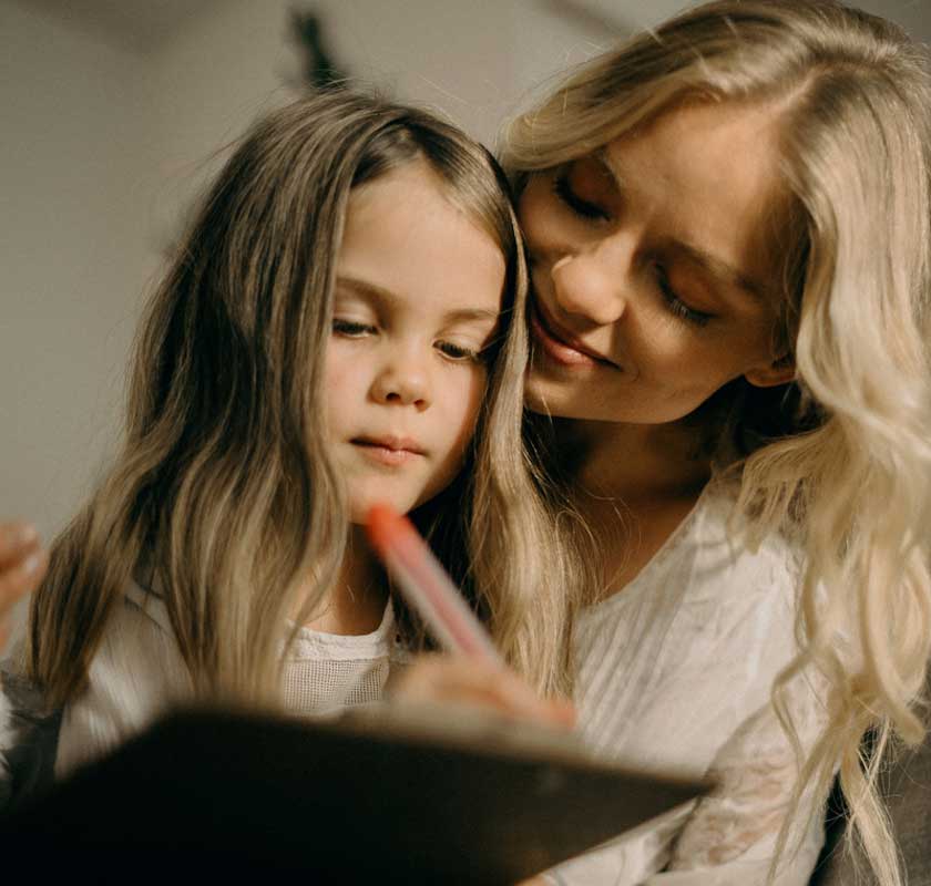 Mother leaning into primary school aged daughter