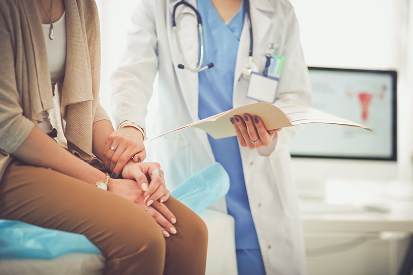 Female patient on consulting bed being cared for by female doctor