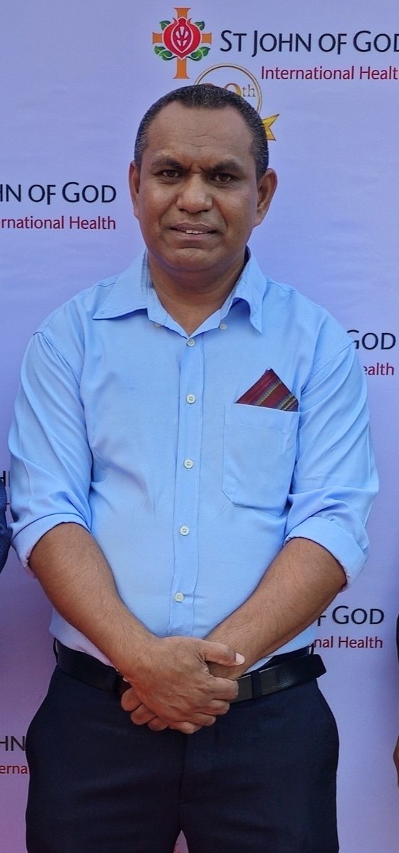 Sr. Justino Godinho Soares standing with his hands together looking at the camera.