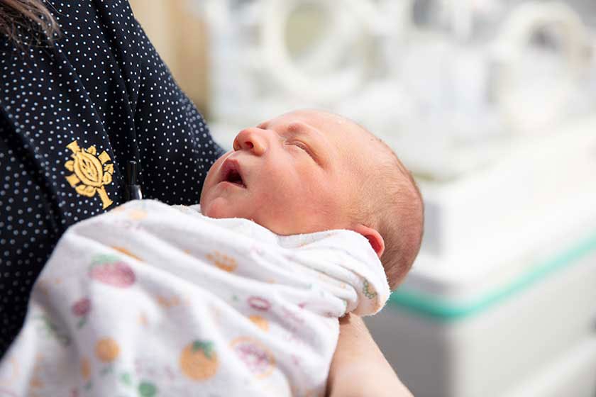 Most popular baby names 2022 heading with baby and nurse