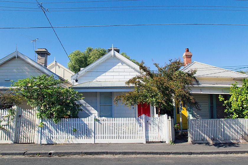 Three small houses with colourful front doors