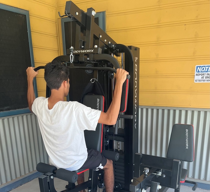Young man using a weights machine