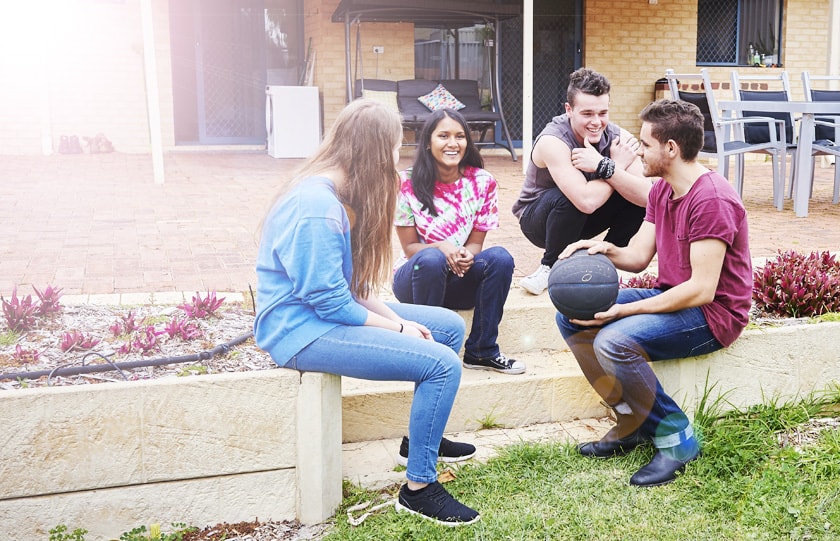 Group of young people talking on back garden step