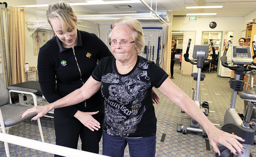 Caregiver with patient in rehabilitation gym