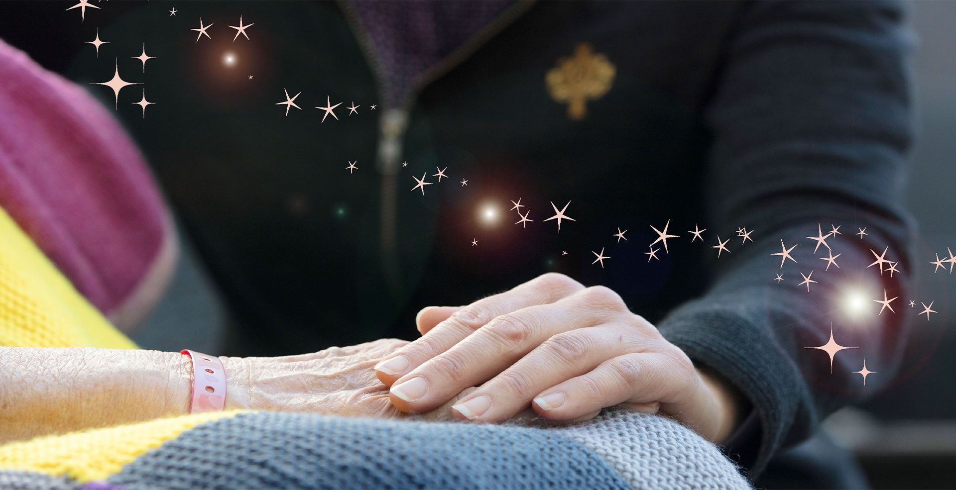 Caregiver hands embracing a patients hands with stars and lighting affect