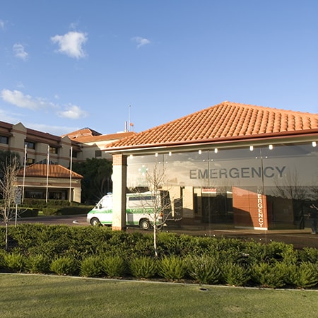 Exterior of the St John of God Murdoch Hospital Emergency Department entrance with an ambulance parked in front