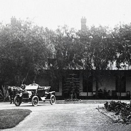 Black and white photograph taken in 1902 of of the exterior of the first St John of God hospital at Subiaco, a horse and motor car sit in its driveway