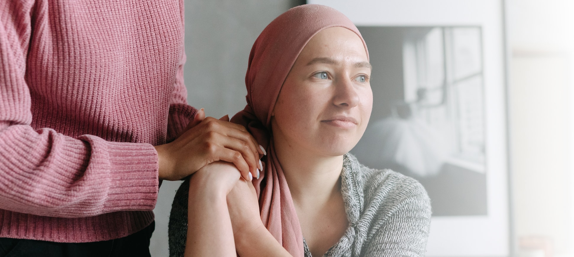 A female cancer patient with a hand on her shoulder