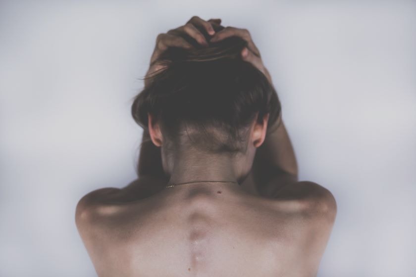 Person holding head in their hands